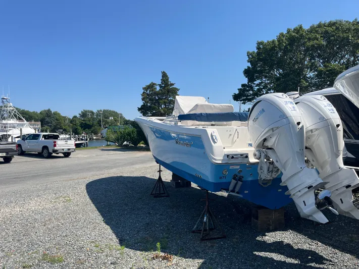  Yacht Photos Pics 2022 Sailfish 320 CC boat with twin outboard engines on a gravel lot.