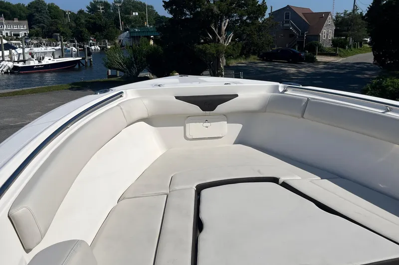  Yacht Photos Pics 2022 Sailfish 320 CC boat interior with cushioned seating in a marina.