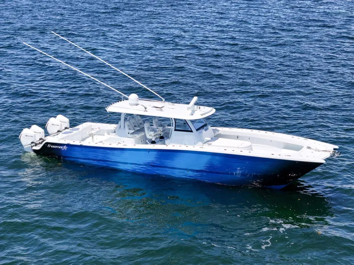  Yacht Photos Pics 2023 Freeman 47 boat on open water, featuring sleek blue and white design.