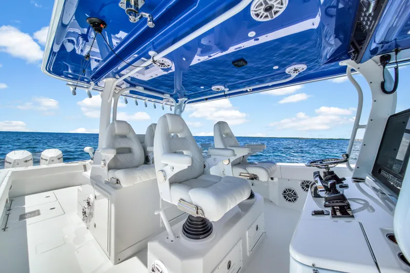  Yacht Photos Pics 2023 Freeman 47 boat interior with white seats and blue canopy on open water.