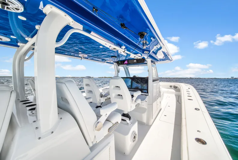  Yacht Photos Pics 2023 Freeman 47 boat with sleek design, white seating, and blue canopy on open water.