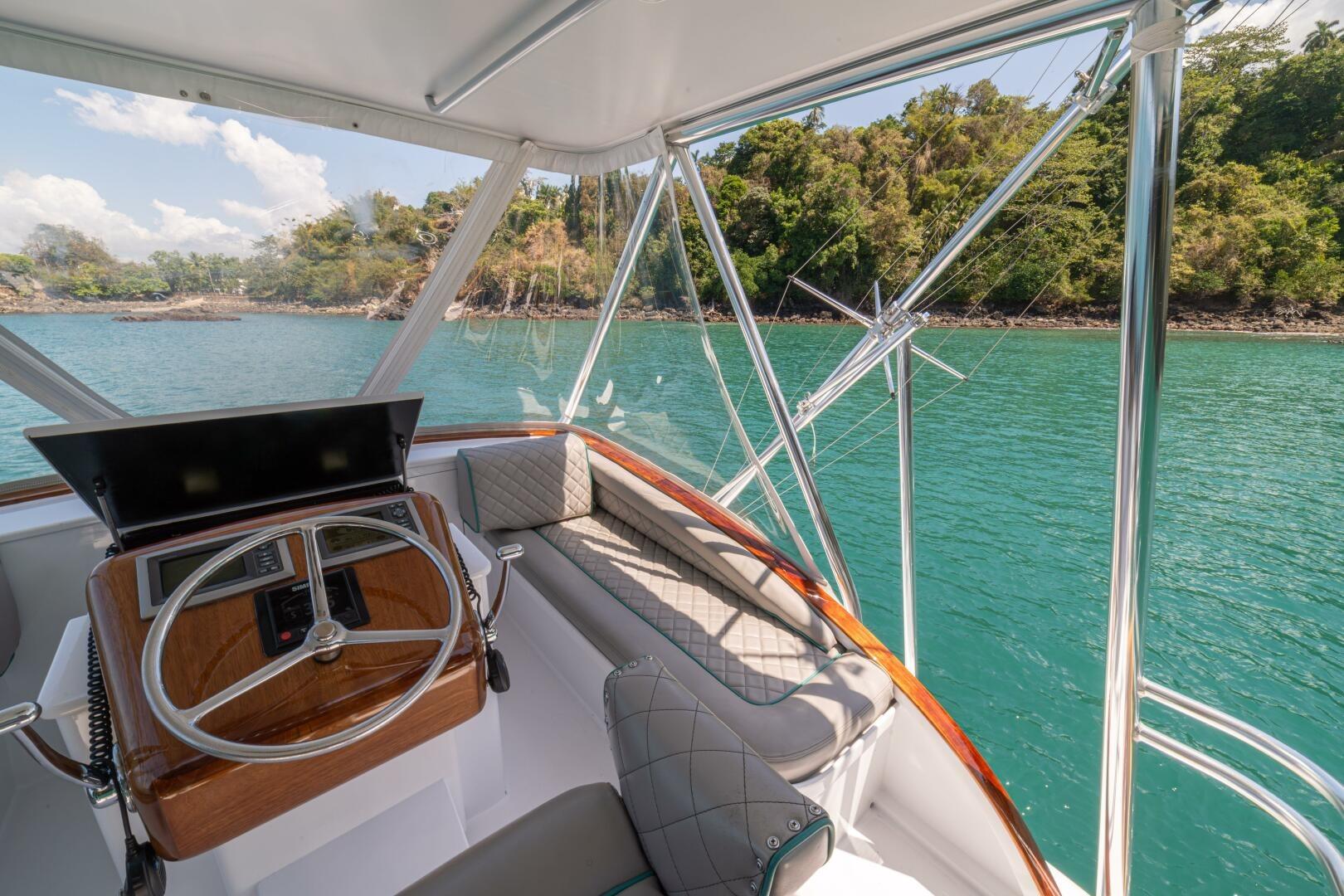 Helm of 1991 Gamefisherman 40 boat with scenic coastal view.