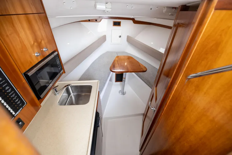  Yacht Photos Pics Interior of 2018 Albemarle 27 Express boat with kitchenette and seating area.
