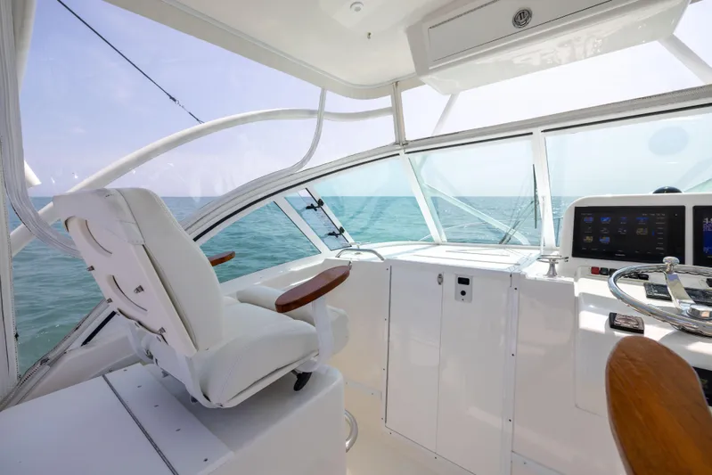  Yacht Photos Pics 2018 Albemarle 27 Express boat interior with helm, white seating, and ocean view.