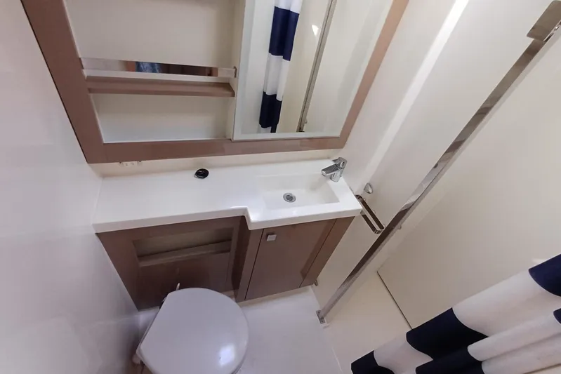  Yacht Photos Pics 2018 Fountaine Pajot Saona 47 bathroom with modern sink, mirror, and shower curtain.