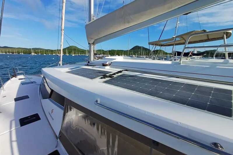  Yacht Photos Pics 2018 Fountaine Pajot Saona 47 catamaran with solar panels, docked in a scenic marina.