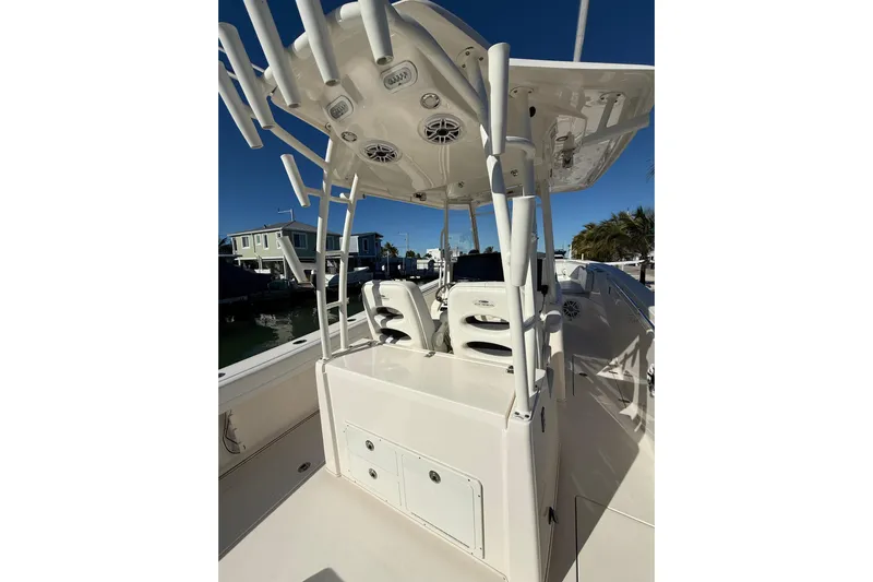  Yacht Photos Pics 2022 Cobia 320 Center Console boat with rod holders and seating, docked under clear sky.