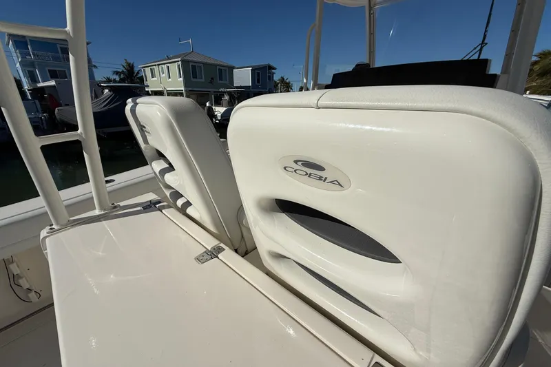  Yacht Photos Pics 2022 Cobia 320 Center Console boat seats with logo, docked near waterfront homes.