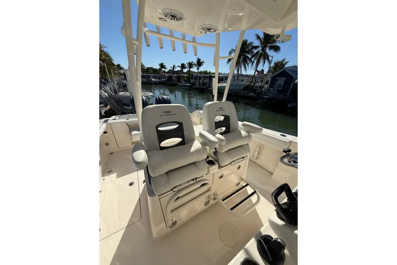 Yacht Photos Pics 2022 Cobia 320 Center Console boat interior with dual seats, docked near palm trees.
