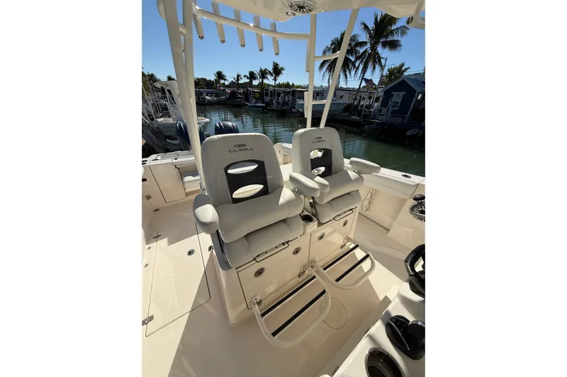  Yacht Photos Pics 2022 Cobia 320 Center Console boat interior with dual seats and palm trees in the background.
