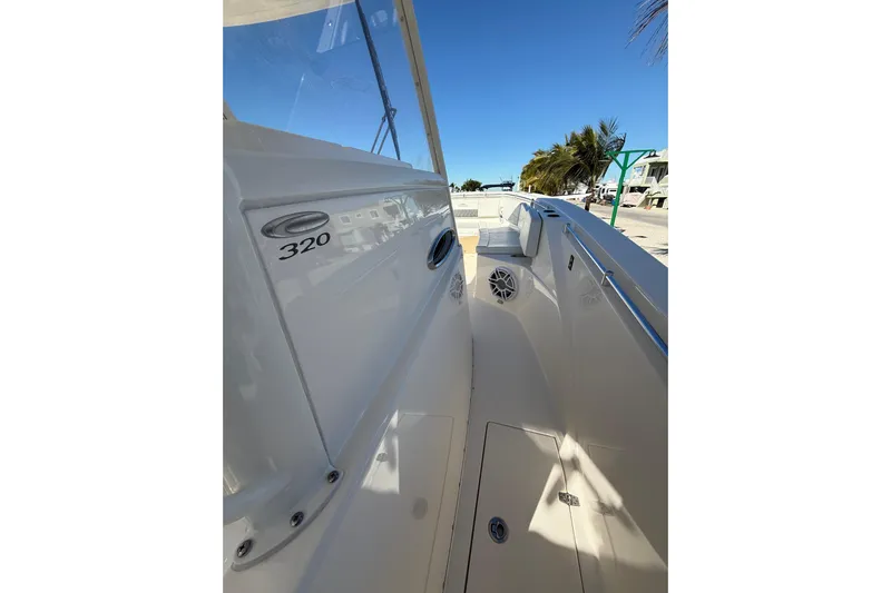  Yacht Photos Pics 2022 Cobia 320 Center Console boat, sleek design, spacious deck, sunny day, palm trees in background.