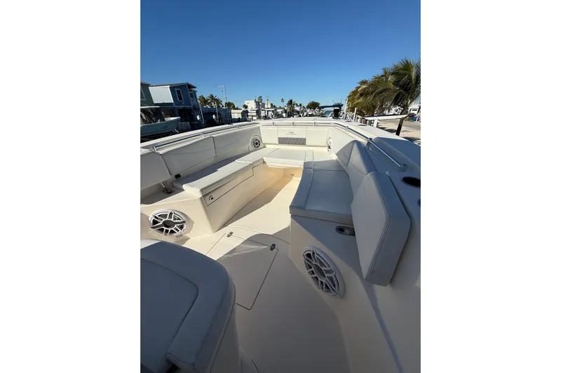  Yacht Photos Pics 2022 Cobia 320 Center Console boat interior with seating and speakers, docked under clear blue sky.