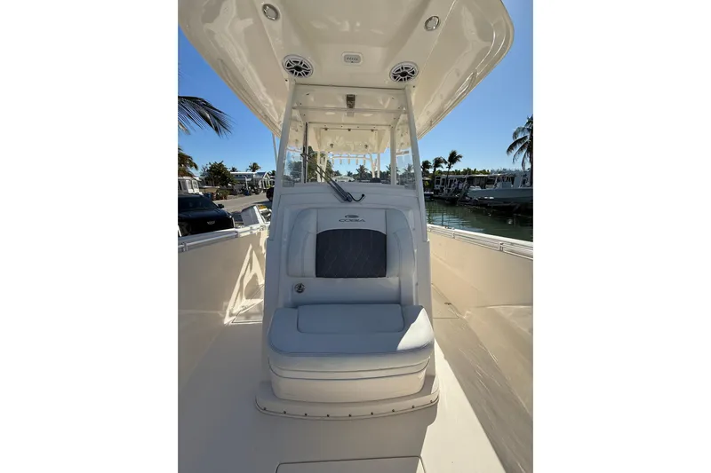  Yacht Photos Pics 2022 Cobia 320 Center Console boat interior with seating, docked near palm trees.