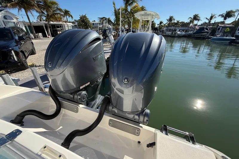  Yacht Photos Pics 2022 Cobia 320 Center Console with twin Yamaha outboard motors docked by palm trees.
