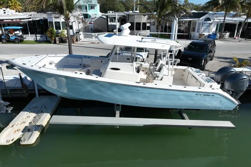  Yacht Photos Pics 2022 Cobia 320 Center Console boat docked, featuring sleek design and dual engines.