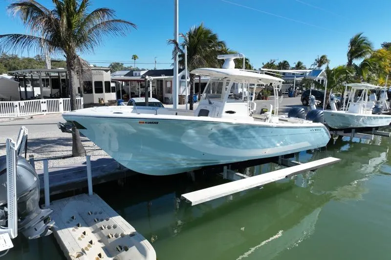  Yacht Photos Pics 2022 Cobia 320 Center Console boat docked by palm trees and waterfront homes.