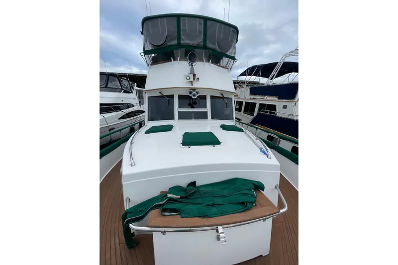 Amazing Grace Yacht Photos Pics 1983 Grand Banks 49 Classic yacht with green covers, docked alongside other boats.