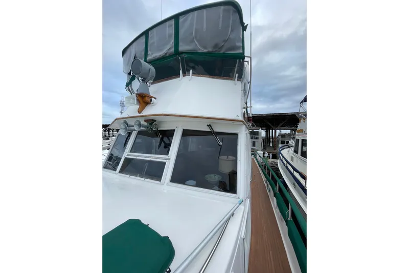 Amazing Grace Yacht Photos Pics 1983 Grand Banks 49 Classic yacht docked, featuring green canopy and wooden deck.