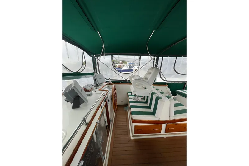 Amazing Grace Yacht Photos Pics 1983 Grand Banks 49 Classic yacht interior with green canopy and striped seating.