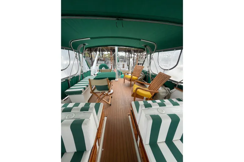 Amazing Grace Yacht Photos Pics 1983 Grand Banks 49 Classic yacht interior with green-striped seating and wooden deck.