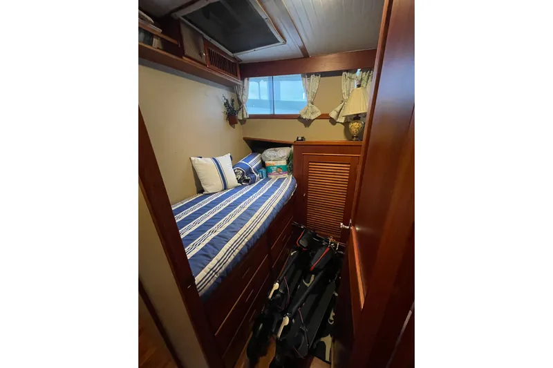 Amazing Grace Yacht Photos Pics Cozy cabin interior of 1983 Grand Banks 49 Classic with striped bedding and wooden furnishings.