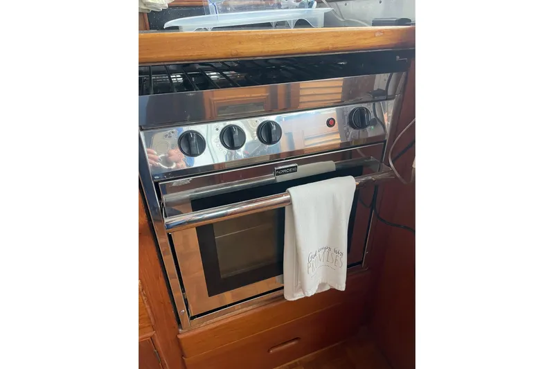 Amazing Grace Yacht Photos Pics Stainless steel oven with control knobs and a towel, inside a 1983 Grand Banks 49 Classic.