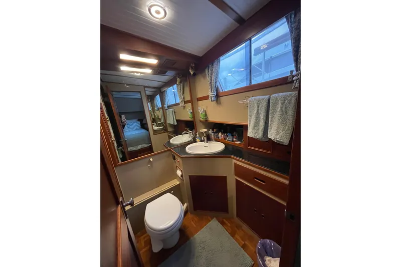 Amazing Grace Yacht Photos Pics Bathroom interior of 1983 Grand Banks 49 Classic yacht, featuring sink, toilet, and wooden cabinetry.
