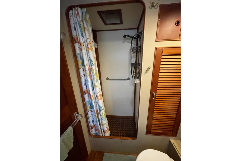Amazing Grace Yacht Photos Pics Shower area in 1983 Grand Banks 49 Classic yacht with floral curtain and wooden accents.