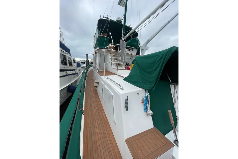 Amazing Grace Yacht Photos Pics 1983 Grand Banks 49 Classic yacht with green covers and wooden deck, docked at marina.