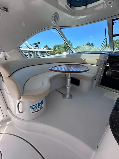 Zincohvid Yacht Photos Pics Interior of 2008 Four Winns V458 yacht with curved seating and wooden table.