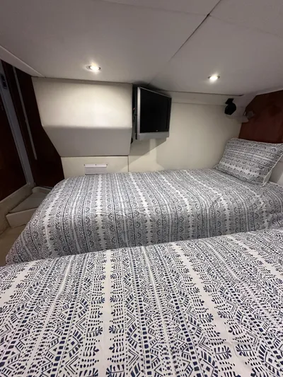 Zincohvid Yacht Photos Pics 2008 Four Winns V458 cabin with twin beds, patterned bedding, and wall-mounted TV.