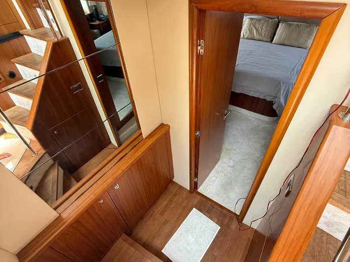  Yacht Photos Pics Interior of 2008 Sunseeker Manhattan 60 yacht, featuring wooden stairs and a cozy bedroom.