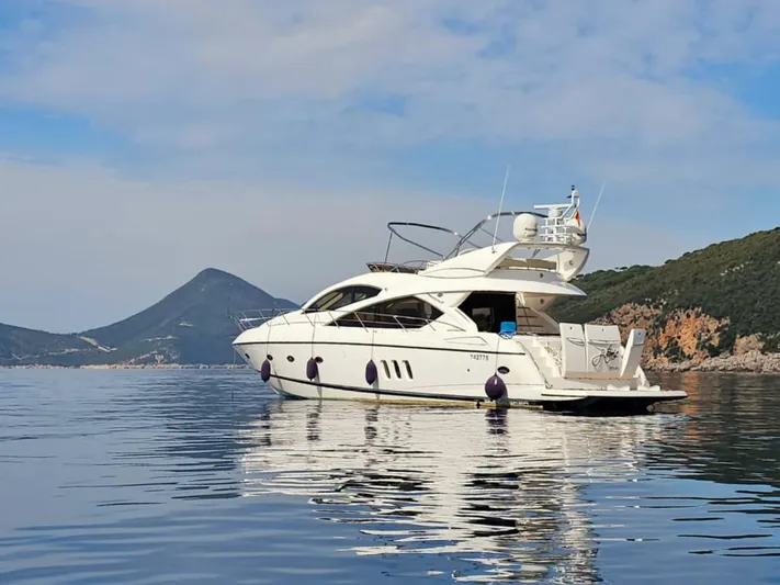  Yacht Photos Pics 2008 Sunseeker Manhattan 60 yacht on calm water with scenic mountain backdrop.