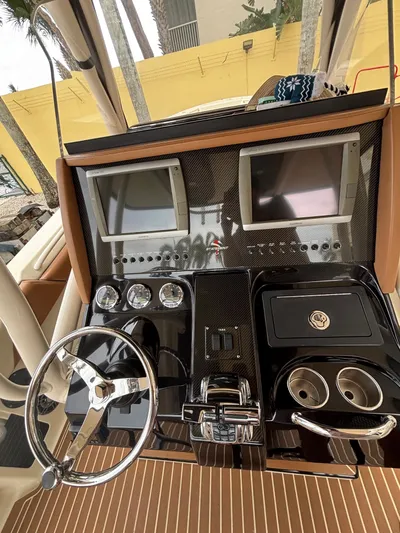  Yacht Photos Pics Control panel of a 2013 Statement 35 Center Console boat with dual screens and steering wheel.