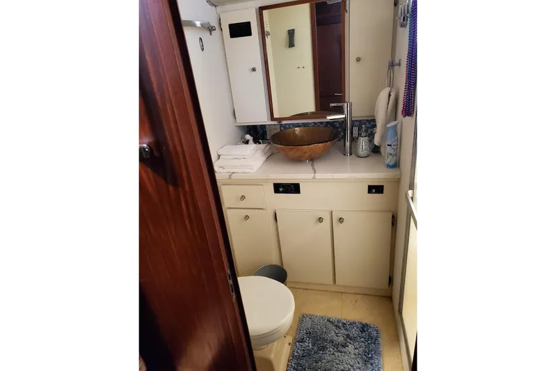  Yacht Photos Pics Bathroom interior of 1984 Hatteras 61 Cockpit MY yacht with wooden sink and modern fixtures.