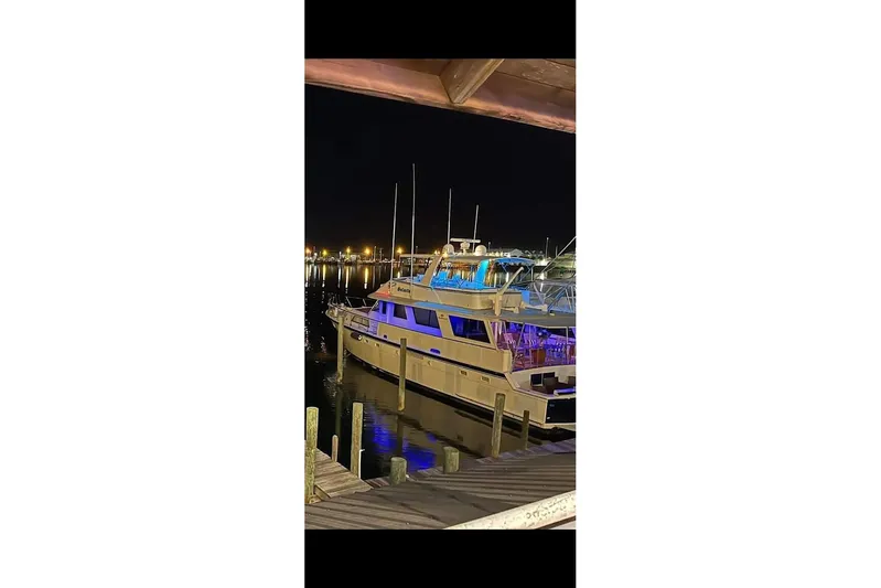  Yacht Photos Pics 1984 Hatteras 61 Cockpit MY yacht docked at night with vibrant lighting.