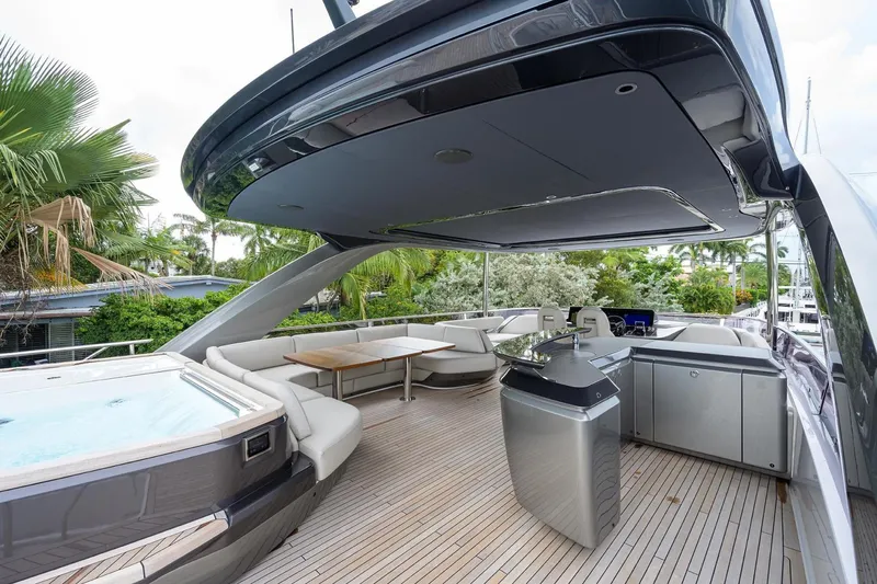Escape Yacht Photos Pics Luxurious 2022 Princess Y85 Motor Yacht deck with seating, jacuzzi, and outdoor kitchen.