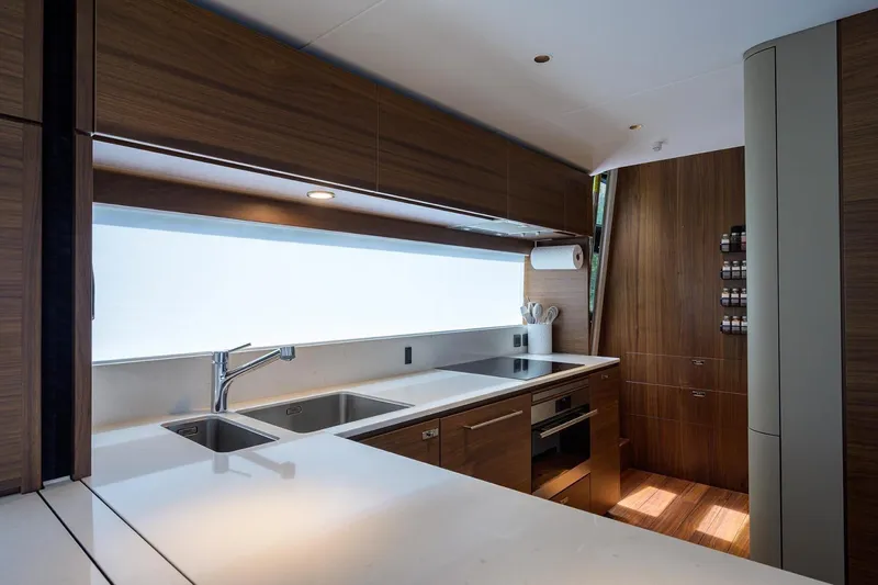 Escape Yacht Photos Pics Luxurious kitchen interior on 2022 Princess Y85 Motor Yacht with modern wood cabinetry.