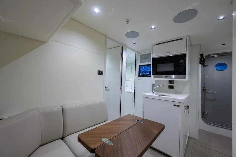 Escape Yacht Photos Pics Modern interior of 2022 Princess Y85 Motor Yacht with kitchenette and seating area.