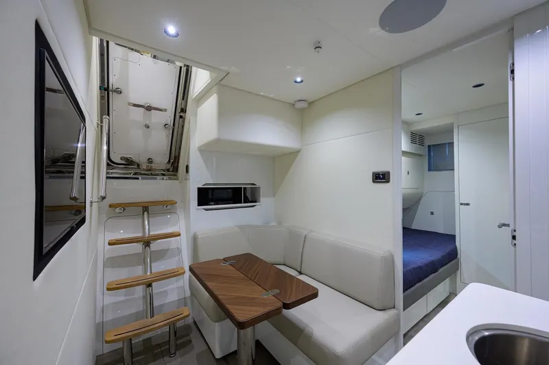 Escape Yacht Photos Pics Interior of 2022 Princess Y85 Motor Yacht with modern seating and compact kitchen area.