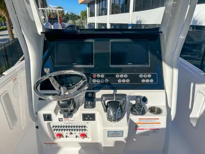  Yacht Photos Pics 2025 Edgewater 262CC boat dashboard with steering wheel and control panel.