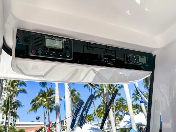  Yacht Photos Pics 2025 Edgewater 262CC boat dashboard with electronic controls, palm trees in the background.