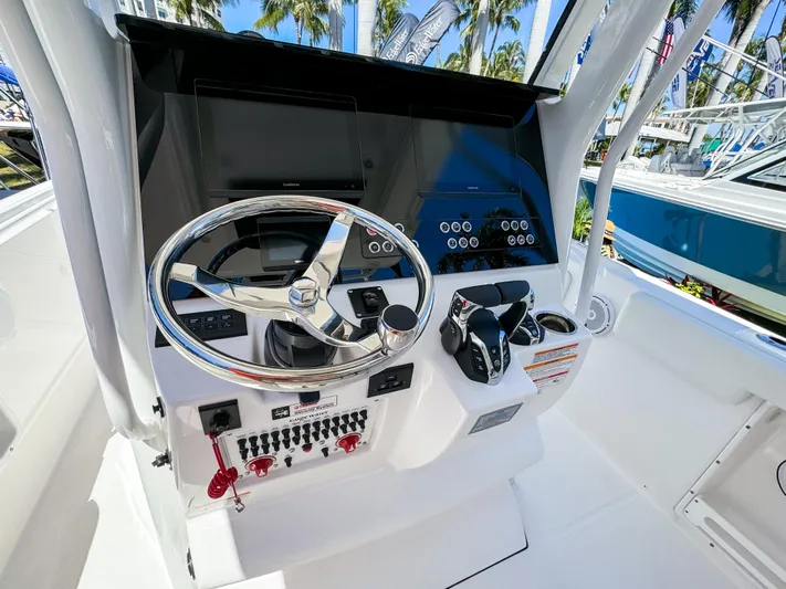  Yacht Photos Pics 2025 Edgewater 262CC boat dashboard with steering wheel and control panel.