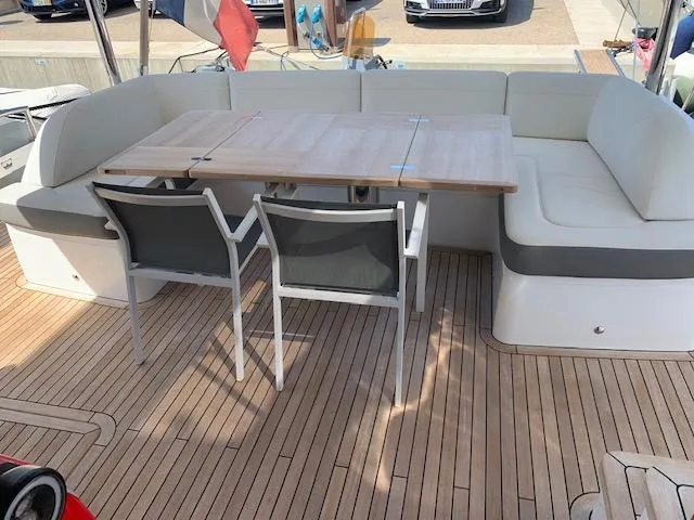  Yacht Photos Pics Luxury yacht deck with seating area, wooden table, and chairs on a Princess 75, 2018 model.