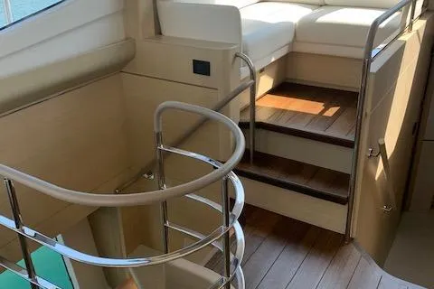  Yacht Photos Pics Interior staircase of 2018 Princess 75 yacht with wooden steps and metal railing.