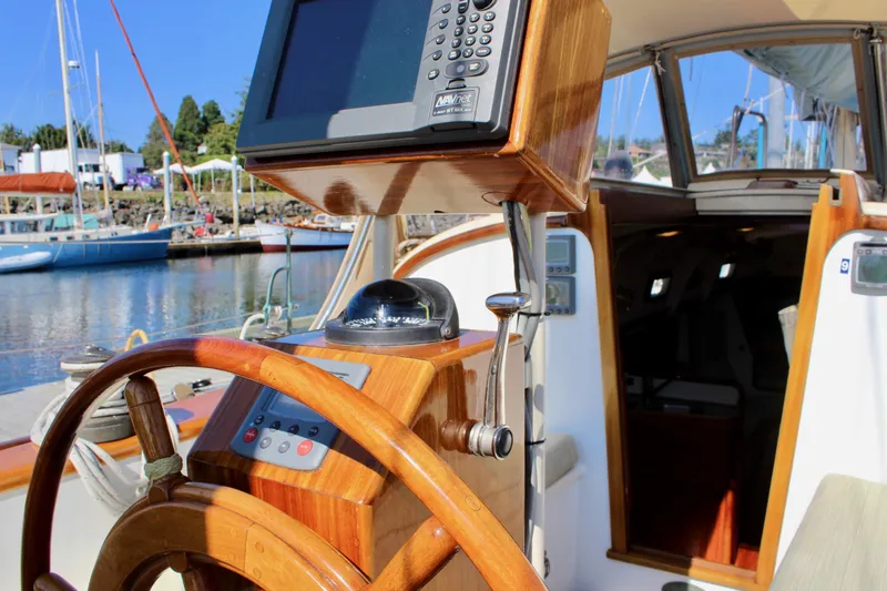 La Vie En Rose Yacht Photos Pics Cockpit of 2012 Custom Gartside Jespersen 40 sailboat with wooden steering wheel and navigation equipment.