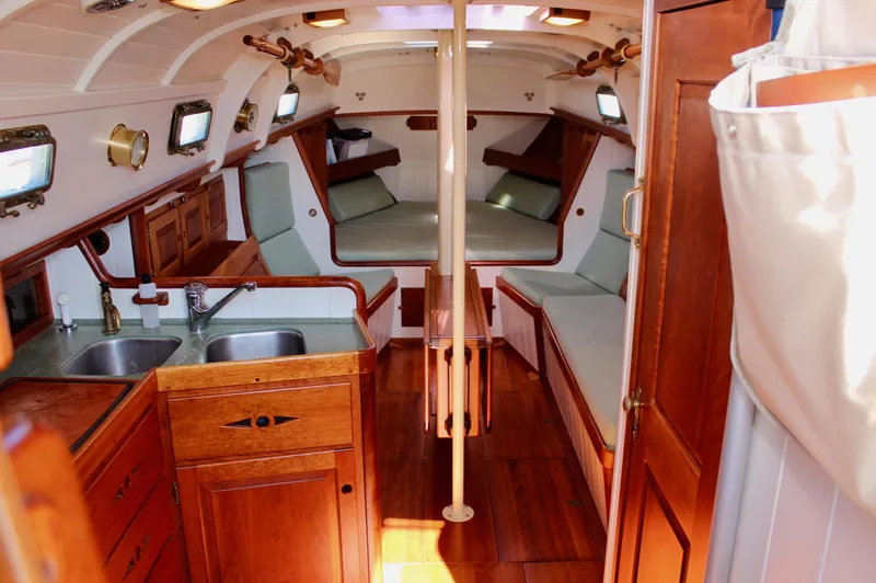 La Vie En Rose Yacht Photos Pics Interior of 2012 Custom Gartside Jespersen 40 sailboat with wooden finishes and cozy seating.