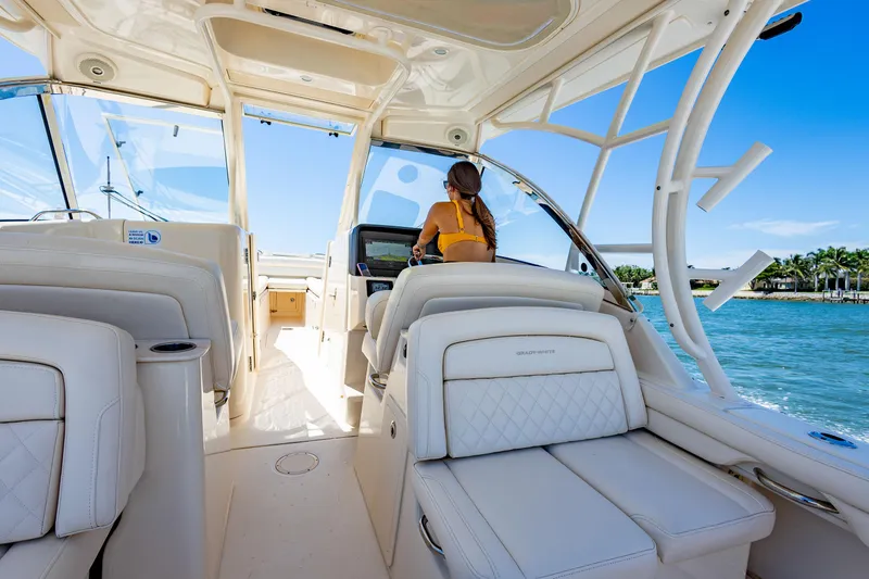  Yacht Photos Pics 2018 Grady-White Freedom 335 interior with woman at helm, cruising on a sunny day.