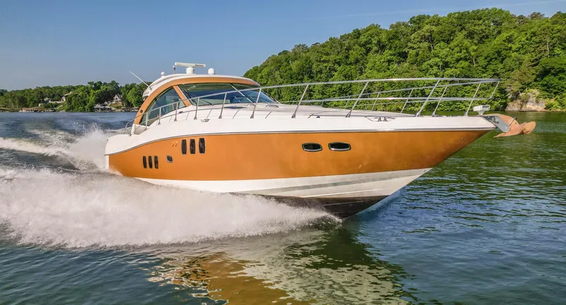  Yacht Photos Pics 2006 Sea Ray 60 Sundancer yacht cruising on a lake with lush green shoreline.