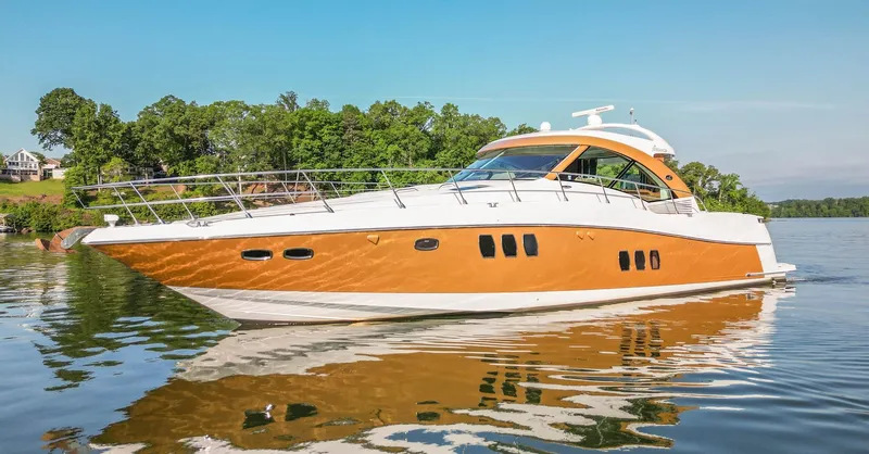  Yacht Photos Pics 2006 Sea Ray 60 Sundancer yacht cruising on a calm lake with lush green shoreline.